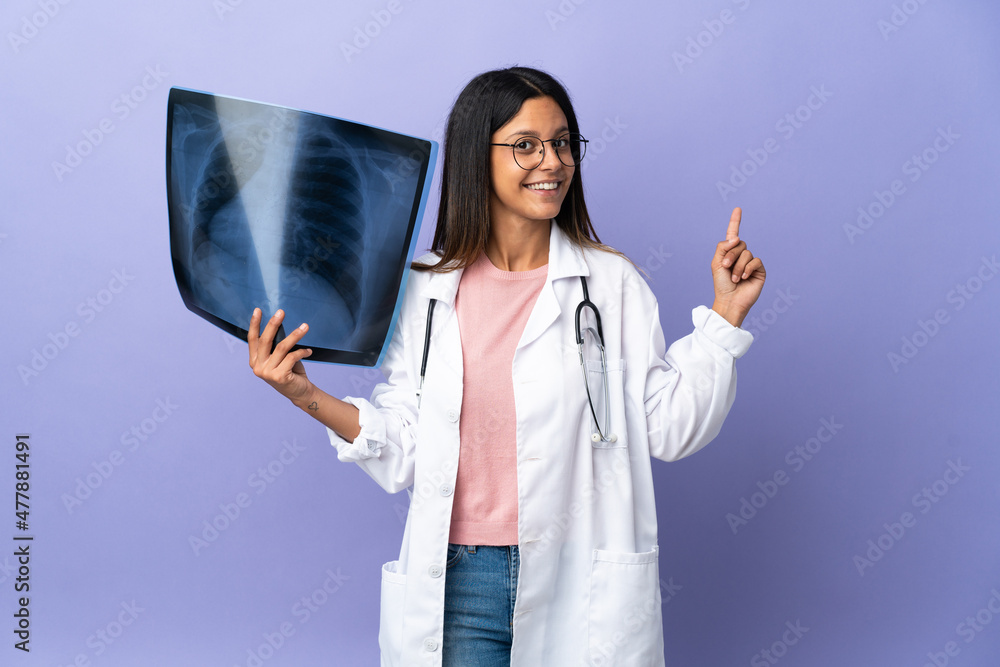 Young doctor woman holding a radiography pointing back Young doctor woman holding a radiography pointing back