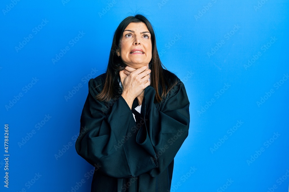 Young hispanic woman wearing judge uniform shouting and suffocate because painful strangle. health problem. asphyxiate and suicide concept. Young hispanic woman wearing judge uniform shouting and suffocate because painful strangle. health problem. asphyxiate and suicide concept.