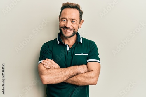 Middle age man wearing casual clothes happy face smiling with crossed arms looking at the camera. positive person.