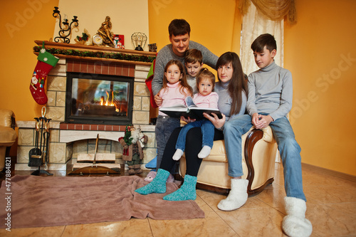Happy young large family at home by a fireplace in warm living room on winter day. © AS Photo Family