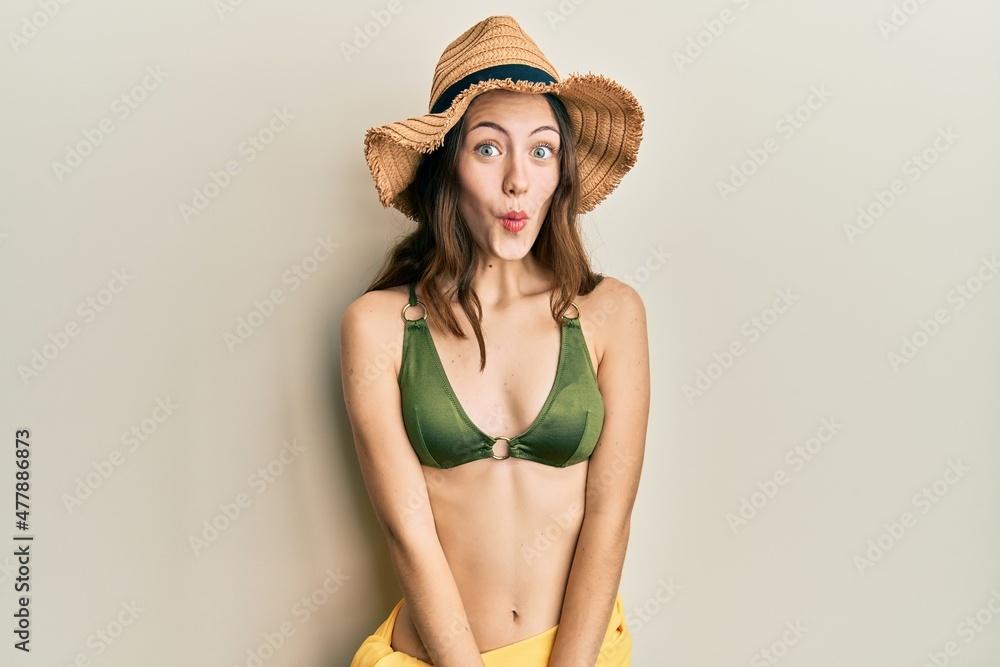 Young brunette woman wearing bikini afraid and shocked with surprise expression, fear and excited face. Young brunette woman wearing bikini afraid and shocked with surprise expression, fear and excited face.