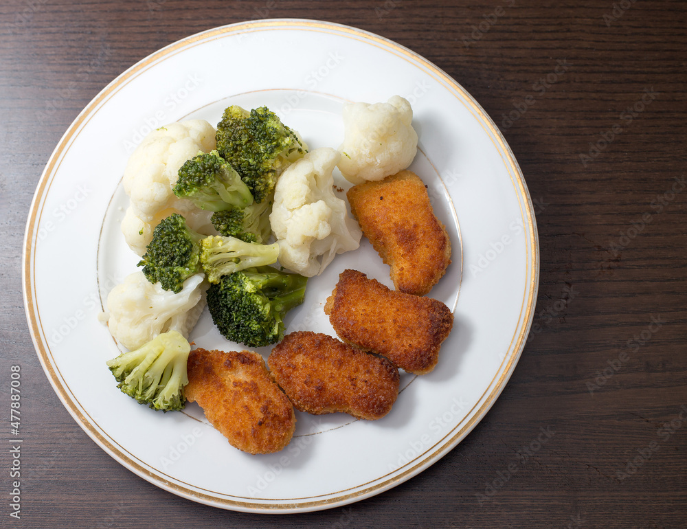 Dinner on a white plate that is on a dark background Dinner on a white plate that is on a dark background