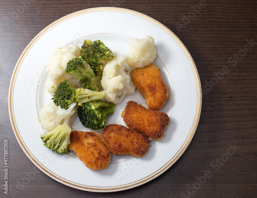 Dinner on a white plate that is on a dark background