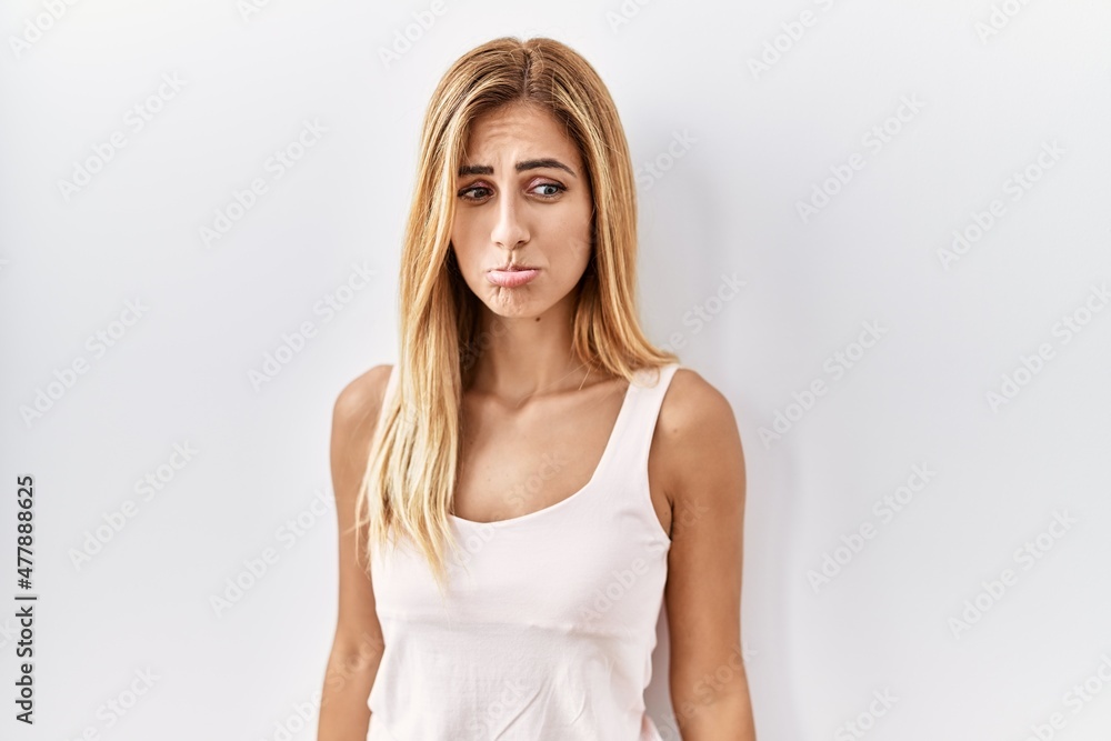 Blonde beautiful young woman standing over white isolated background depressed and worry for distress, crying angry and afraid. sad expression. Blonde beautiful young woman standing over white isolated background depressed and worry for distress, crying angry and afraid. sad expression.