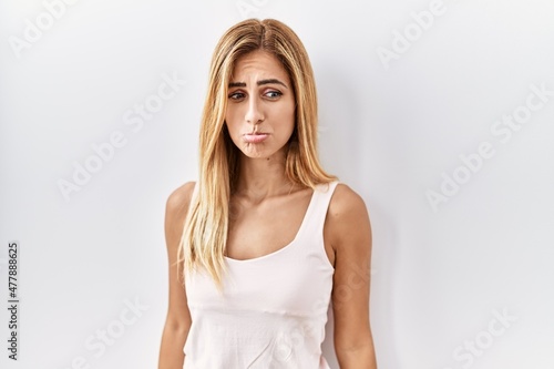 Blonde beautiful young woman standing over white isolated background depressed and worry for distress, crying angry and afraid. sad expression. © Krakenimages.com