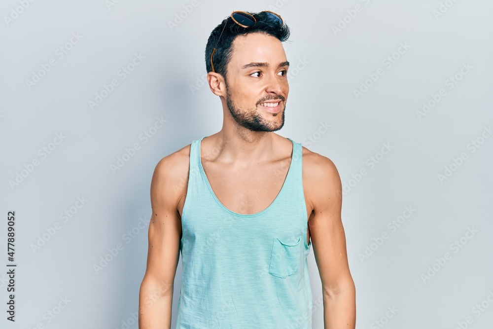 Young hispanic man wearing summer style looking to side, relax profile pose with natural face and confident smile. Young hispanic man wearing summer style looking to side, relax profile pose with natural face and confident smile.