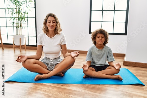Mother and son smiling confident training yoga at sport center
