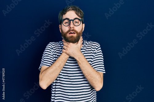 Caucasian man with beard wearing striped t shirt and glasses shouting and suffocate because painful strangle. health problem. asphyxiate and suicide concept.