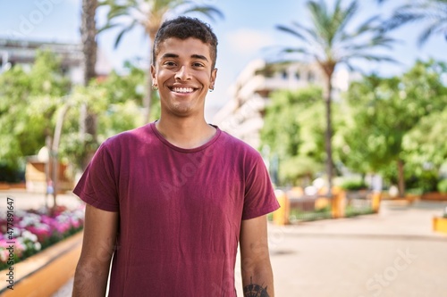 Young latin man smiling happy standing at the city.