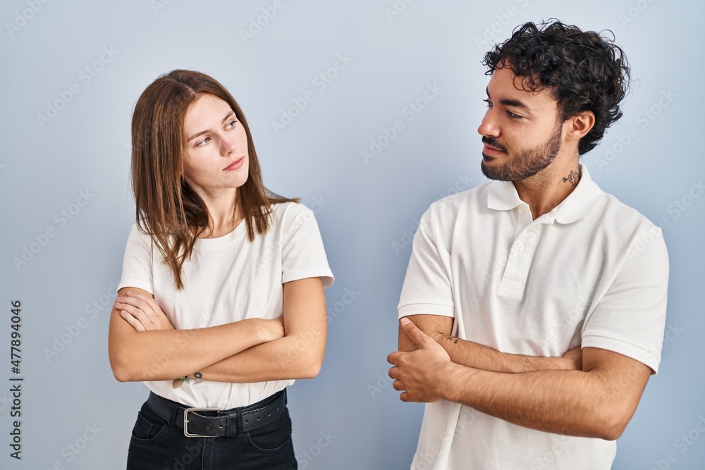 Young couple wearing casual clothes standing together looking to the side with arms crossed convinced and confident Young couple wearing casual clothes standing together looking to the side with arms crossed convinced and confident
