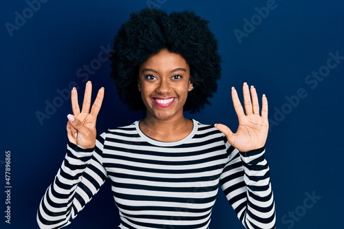 Young african american woman wearing casual clothes showing and pointing up with fingers number eight while smiling confident and happy.