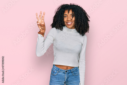 Young african american girl wearing casual clothes showing and pointing up with fingers number three while smiling confident and happy.