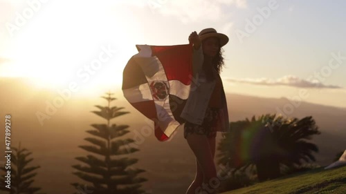 woman with dominican flag at sunset