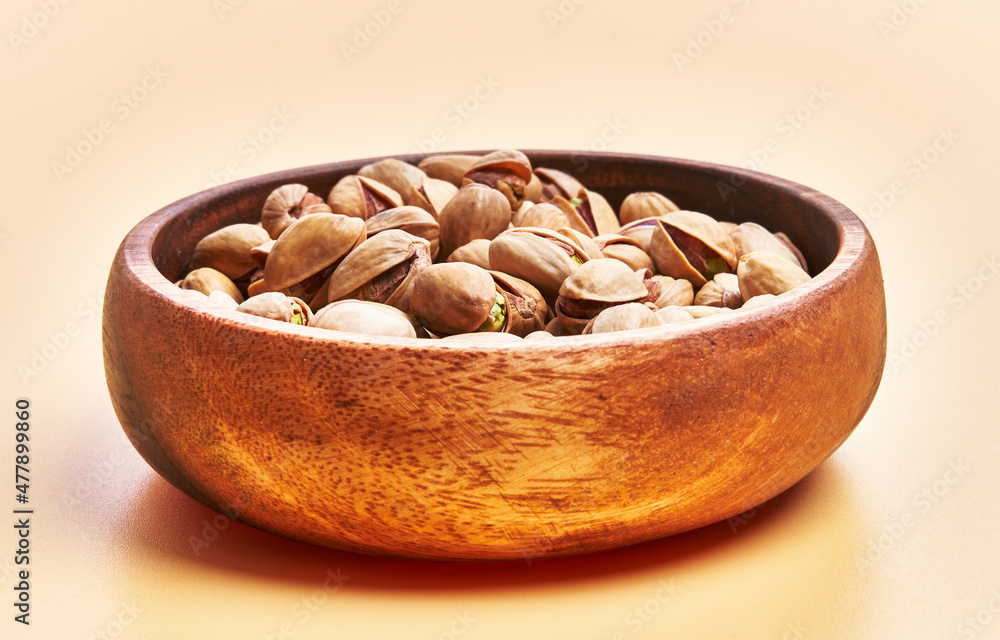 Bowl of pistachios over yellow background Bowl of pistachios over yellow background