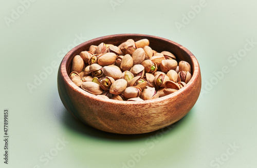  Bowl of pistachios over green background