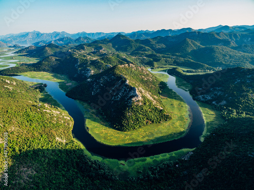 Crnojevica river makes a loop around the green pyramidal mountain