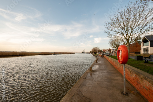 Reedham, Norfolk, UK – January 2022. A view down the River Yare in the village of Reedham in the Norfolk Broads National Park. Captured early morning on a bright but cold and breezy winter morning photo