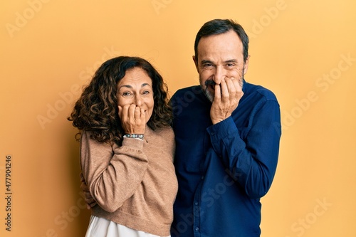 Foto Middle age hispanic couple wearing casual clothes laughing and embarrassed giggl