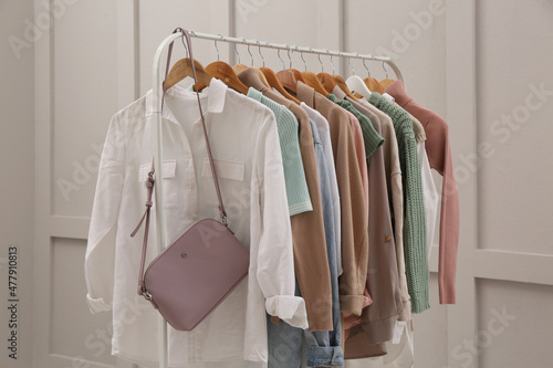 Rack with stylish women's clothes near light wall © New Africa