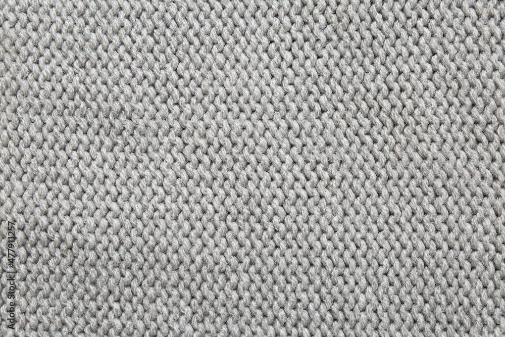 Beautiful grey knitted fabric as background, top view Beautiful grey knitted fabric as background, top view