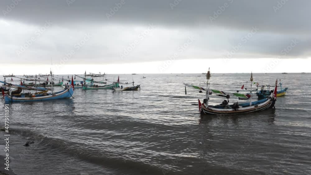 Rows of traditional wooden fishing boats at the port of Banyuwangi, Indonesia on a hot summer day Rows of traditional wooden fishing boats at the port of Banyuwangi, Indonesia on a hot summer day