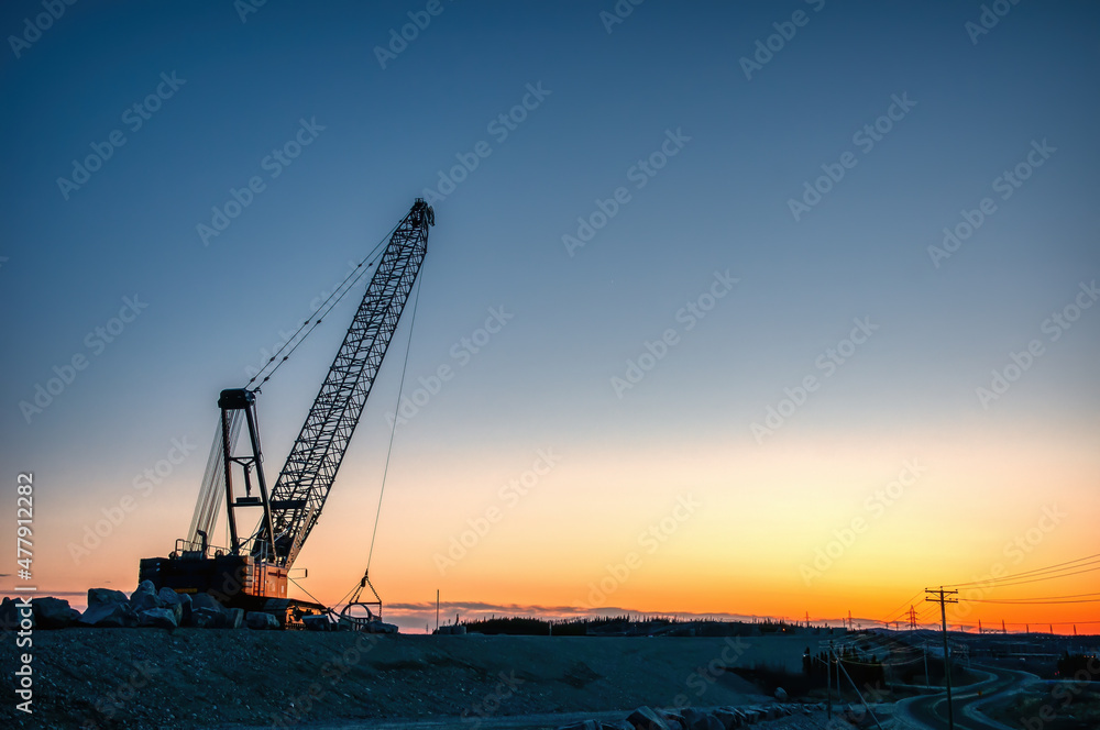 Cable excavator at sunset on construction site