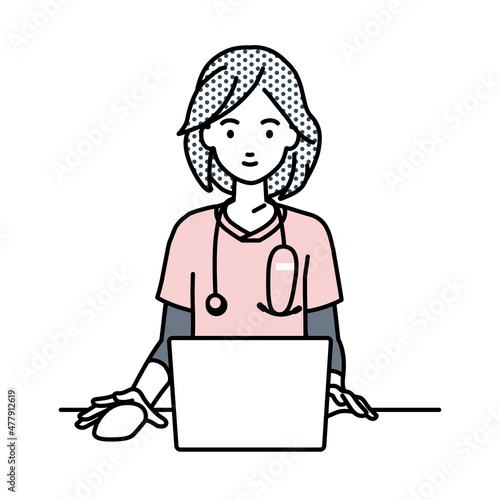 デスクで座ってPCを使っている看護師の女性