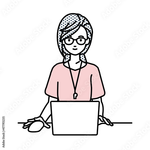 デスクで座ってPCを使っている教師の女性