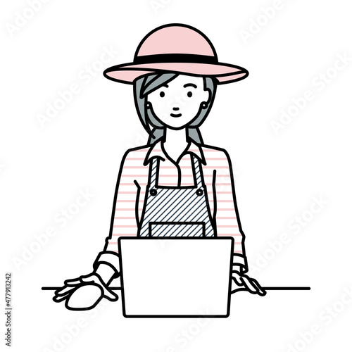デスクで座ってPCを使っている農家の女性