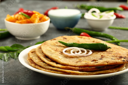`Indian street foods- aloo paratha served with potato curry and fresh raita.