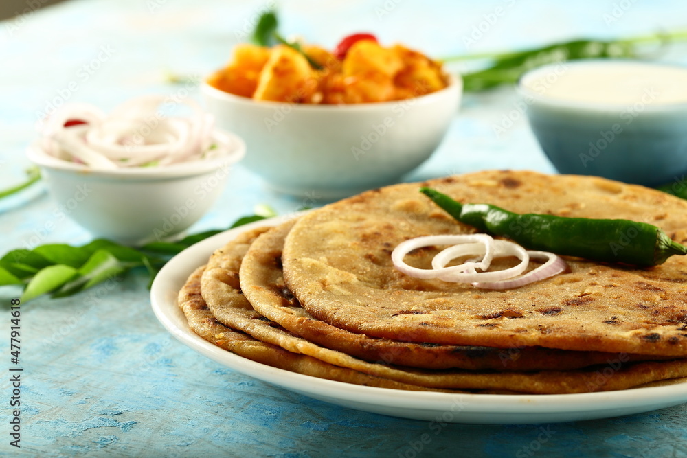 Fresh homemade  aoo paratha served with raita and potato curry- Punjabi dhaba style cooking.