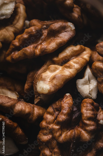 Heap of unshelled walnuts top view dark image full frame nuts macro