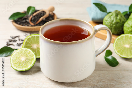 Cup of tasty bergamot tea on white wooden table