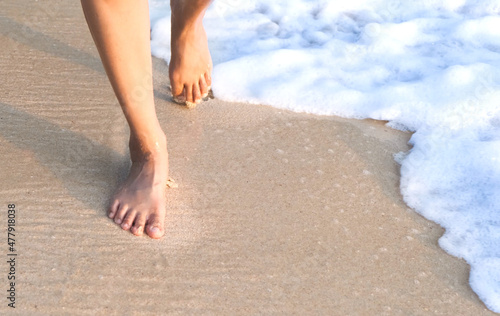 woman walking on the beach in the morning Her feet touch the sea that is clean.soft focus