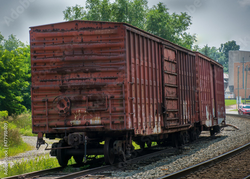 Two rusty railroad boxcars sitting abandoned on track