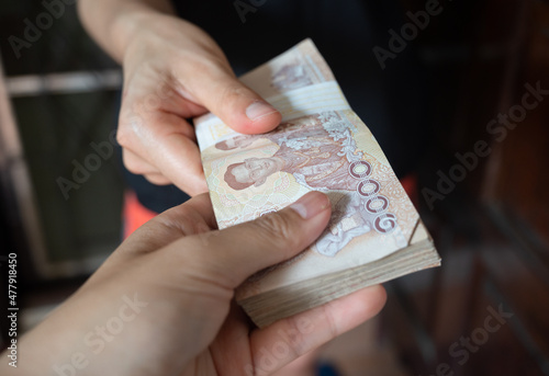 Cropped shot view of someone giving the money (Thailand 1,000 Baht) to other person Fototapeta