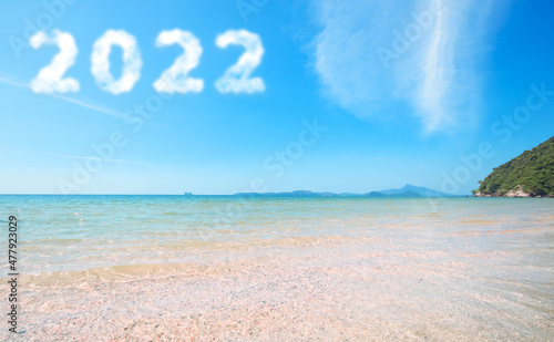 2022 in the sky. Concept Start new year 2022 written with numbers rising from the cloud the coast of the sea, beach