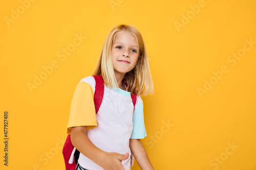 little girl gestures with his hands yellow color background