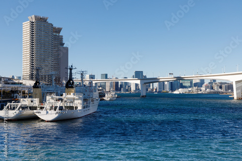 東京湾、岸壁に停泊する船と背景に見える首都高、港区方面のビル群 © maruboland