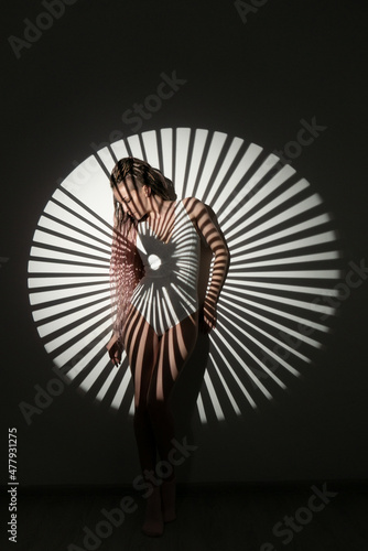 Photography Lonely woman in white bodysuit posing against the wall