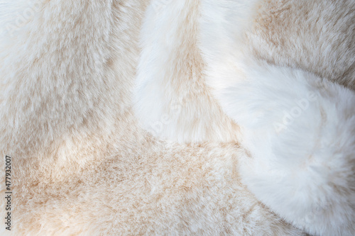 Close-up white fur background with abstract glowing sunlight shadows.