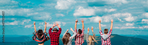 Friends summer travel vacation banner. Group of hikers with arms up on the top of the mountain, raising hands to the sky. Friendship freedom summer holiday concept.