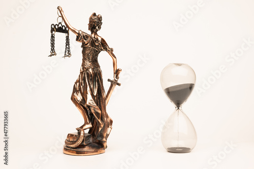Justilia or Themis (Symbol of Justice) statue and hourglass isolated on white background with clipping path
