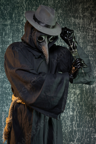 Plague doctor with a syringe of medicine or poison