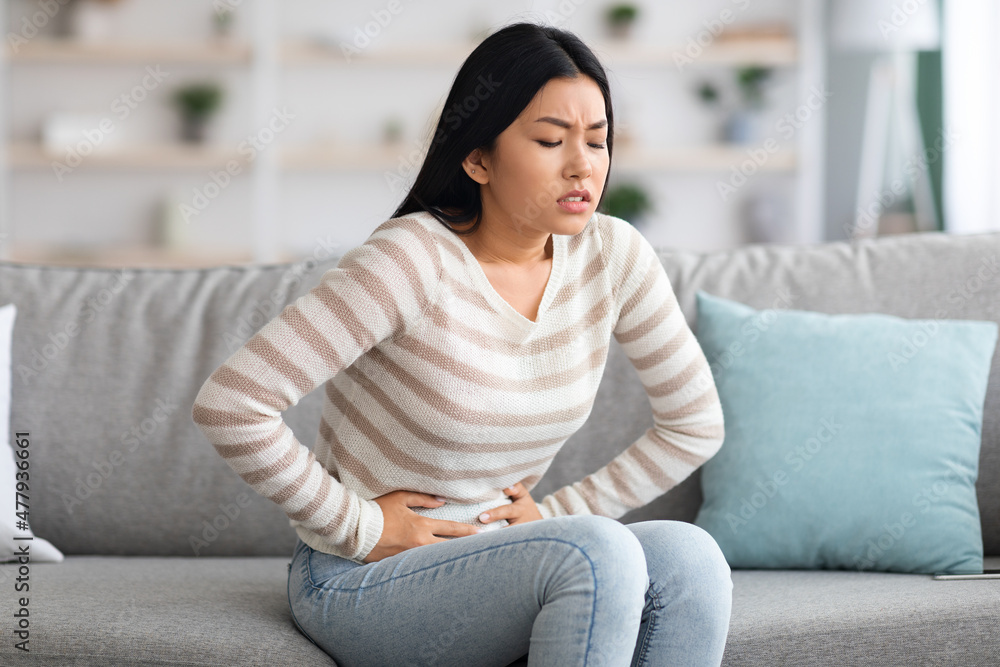 Stomach Ache. Sick Asian Woman Suffering From Acute Abdominal Pain At Home Stomach Ache. Sick Asian Woman Suffering From Acute Abdominal Pain At Home