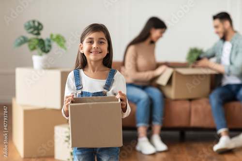 Happy young family packing or unpacking boxes