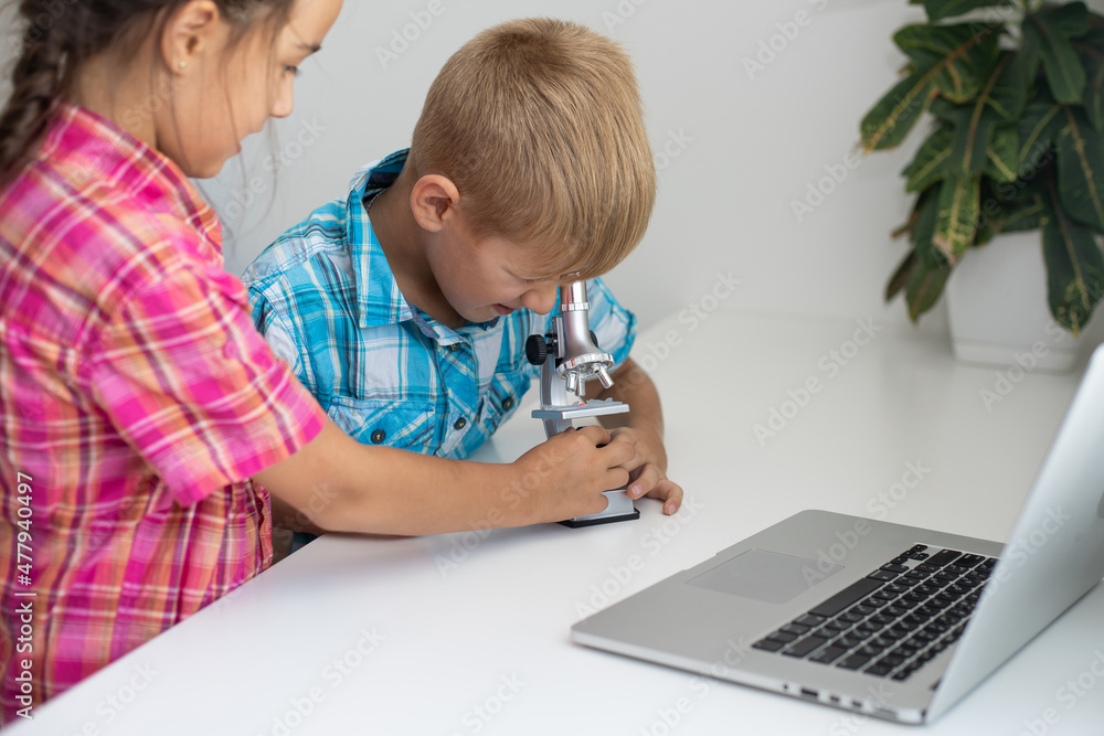 renewable energy, children, technology, science and people concept - kids or friends with laptop computer and microscope model renewable energy, children, technology, science and people concept - kids or friends with laptop computer and microscope model