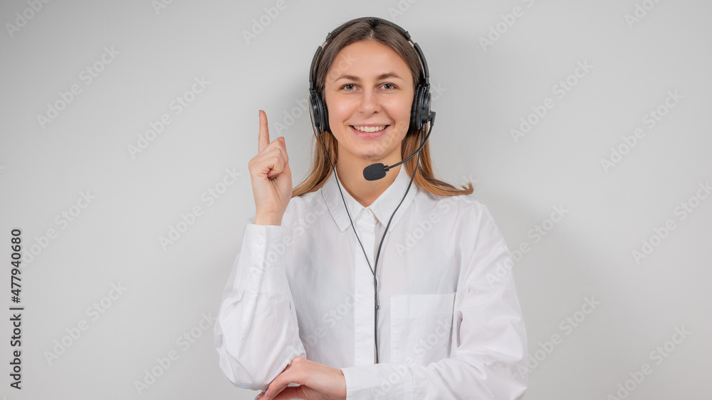 Portrait of smiling support female phone operator in headset, against grey background. Consulting and assistance service call center. Portrait of smiling support female phone operator in headset, against grey background. Consulting and assistance service call center.