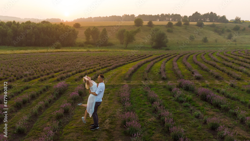Beautiful happy couple on purple lavender field, having fun on floral glade, summer nature, love concept