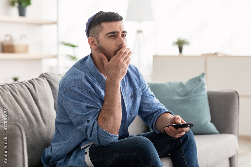 Bored jewishman watching television sitting on couch Bored jewishman watching television sitting on couch